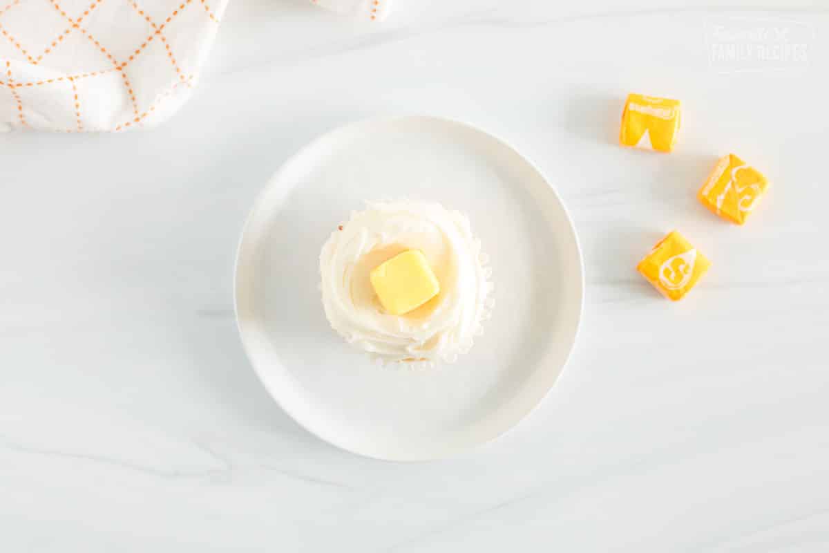 Cupcake with white frosting and a yellow starburst in the middle
