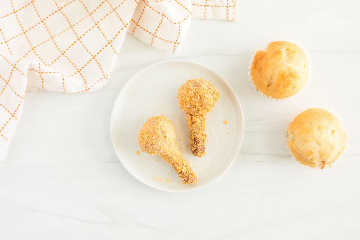 Donut holes on a piece of pretzel stick, dipped in frosting and rolled in cornflakes
