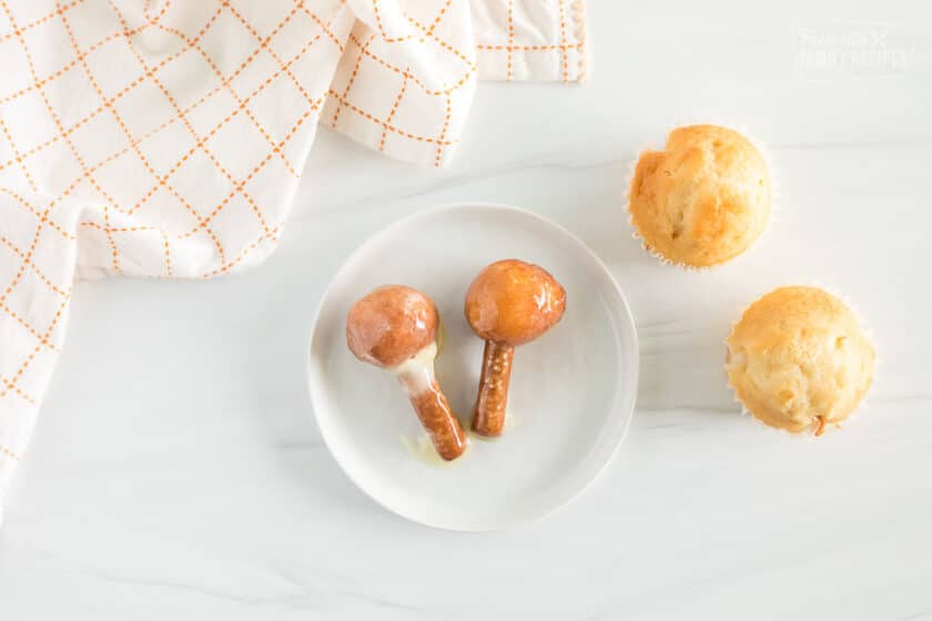 Donut holes on a piece of pretzel stick, dipped in frosting.