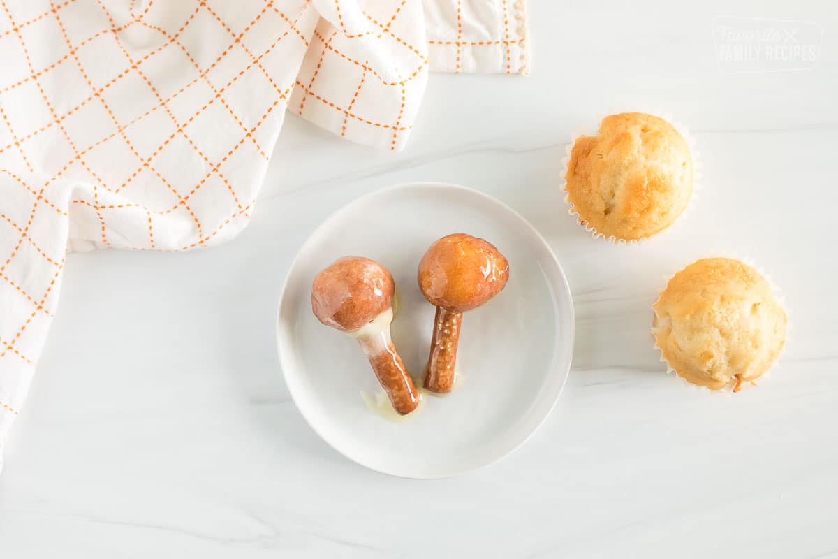 Donut holes on a piece of pretzel stick, dipped in frosting.