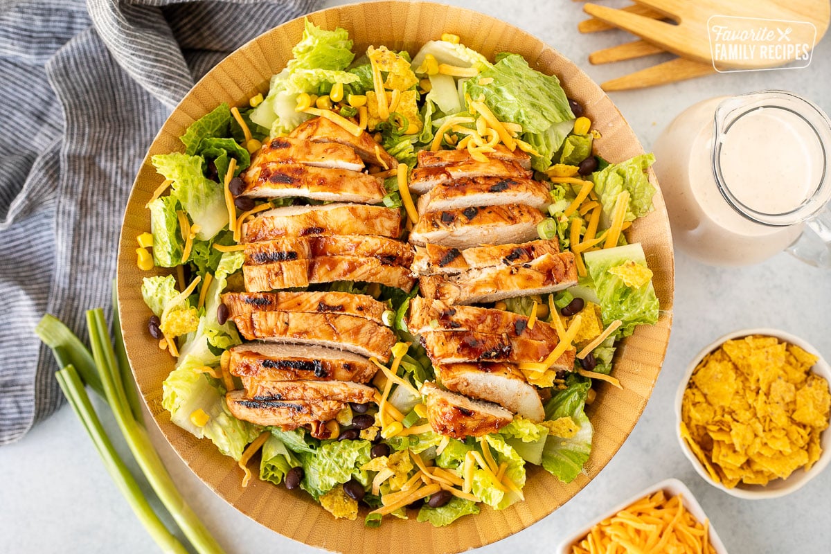 Barbecue Chicken Salad in a salad bowl with dressing on the side.