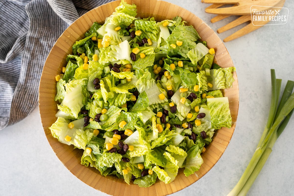 Salad bow with chopped romaine lettuce, green onion, corn and black beans.