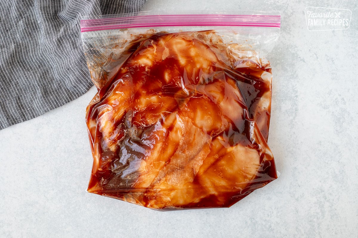 Ziplock bag with chicken breasts marinating in barbecue sauce.