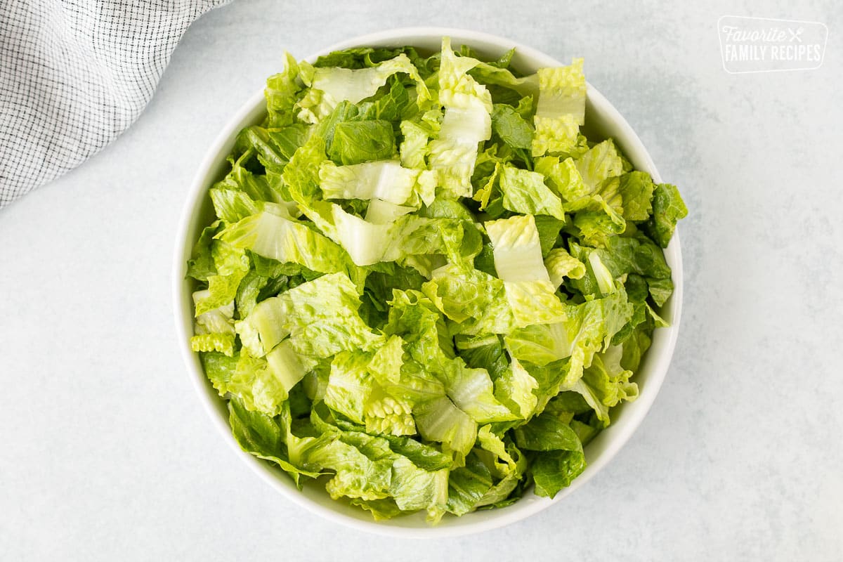 Glass bowl with chopped romaine lettuce.