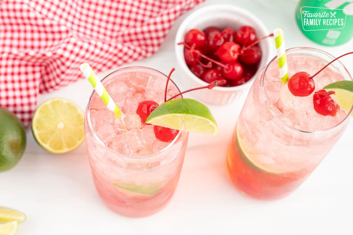 Cherry Limeade topped with a lime wedge, two cherries and a straw.