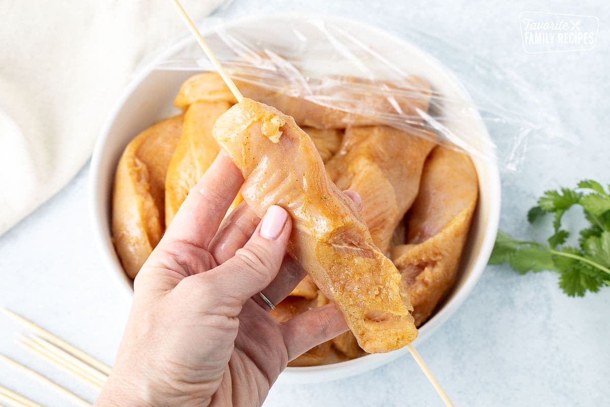 Stabbing a chicken strip with a wooden skewer.