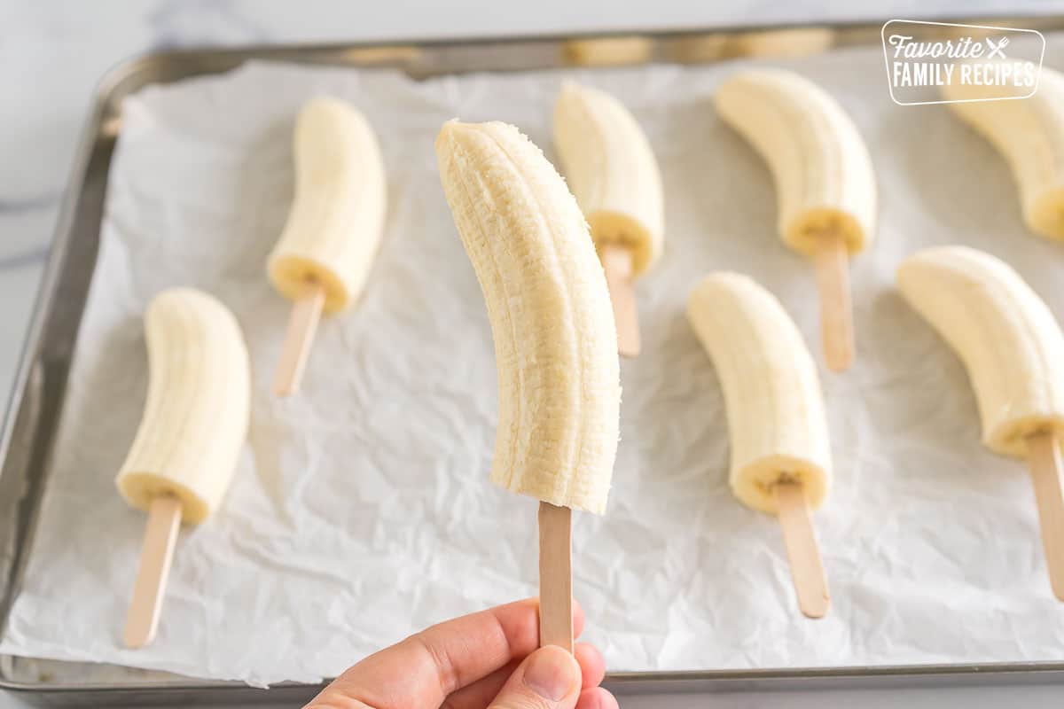 A frozen banana on a popsicle stick