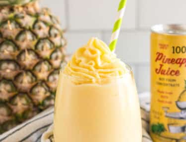 A Dole Whip in a glass with a green straw