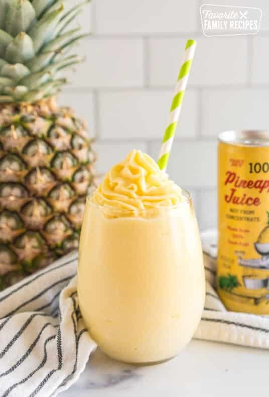 A Dole Whip in a glass with a green straw