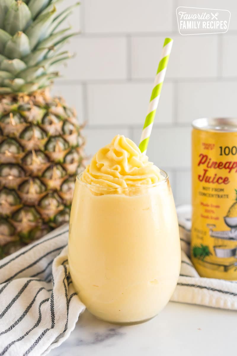 A Dole Whip in a glass with a green straw