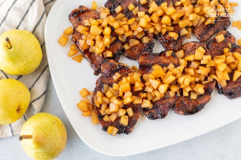 Gilled Pork Chops with Spiced Pears on a glass platter.