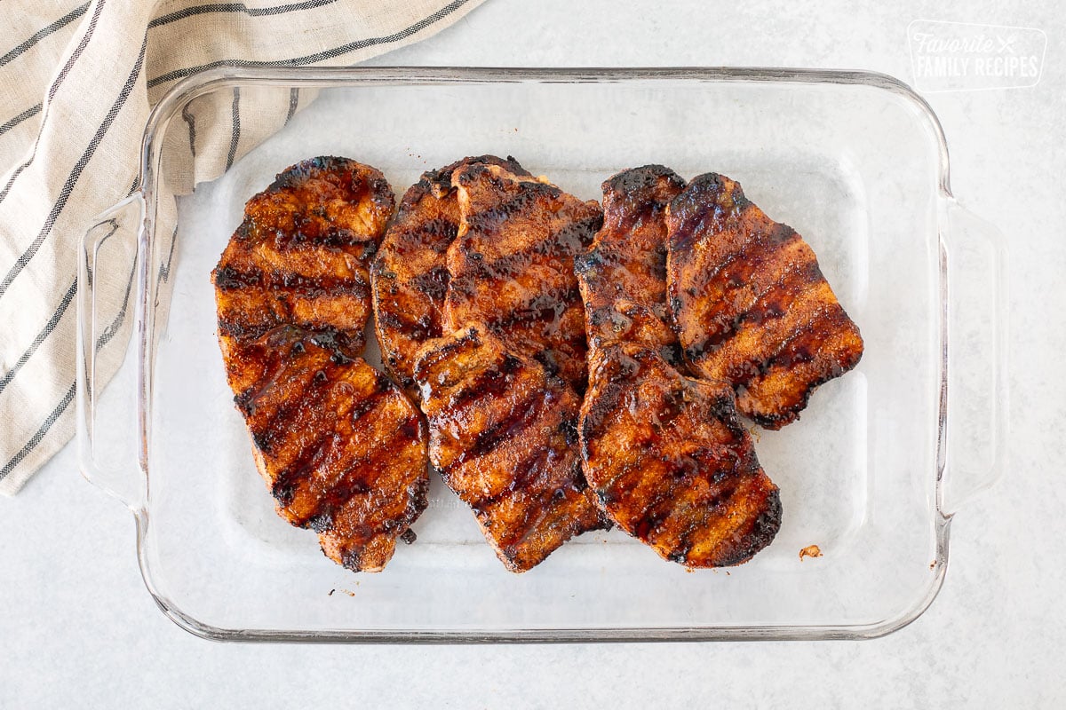 Glass dish with grilled pork chops.