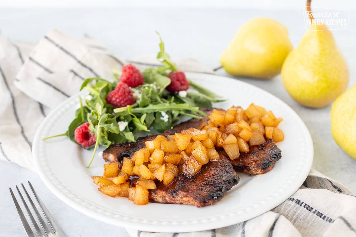 Plate of Grilled Pork Chops with Spiced Pears with a side salad.