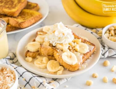 French toast topped with bananas, coconut flakes, coconut syrup, whipped cream, and macadamia nuts