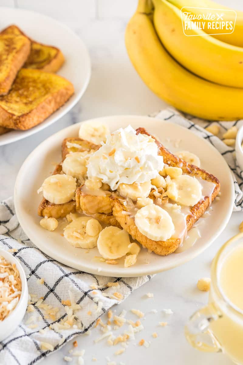 French toast topped with bananas, coconut flakes, coconut syrup, whipped cream, and macadamia nuts