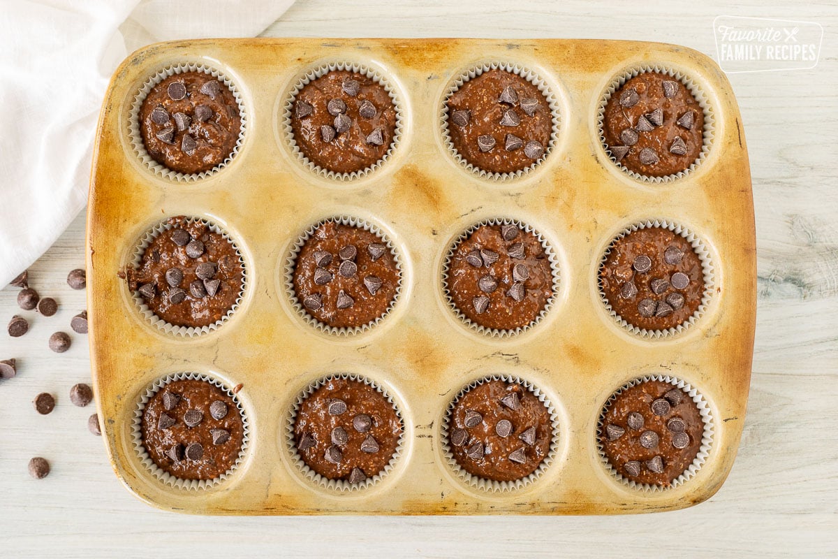 Healthy Chocolate Chip Muffins unbaked in liners in the cupcake pan.