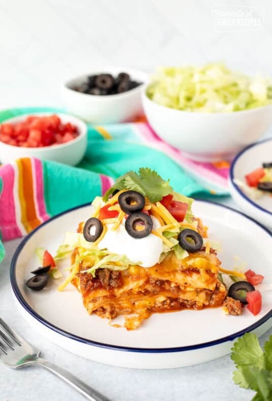 Plate with a piece of Mexican Lasagna with taco toppings.