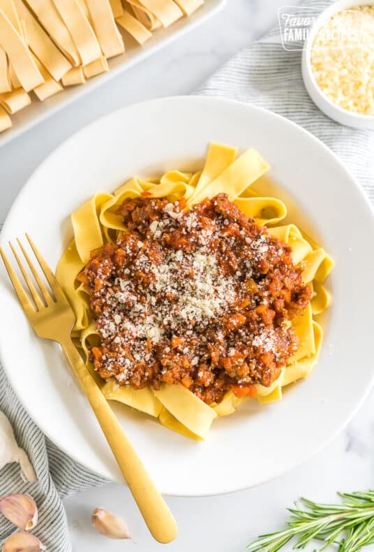 A bowl of Pappardelle Bolognese topped with parmesan cheese