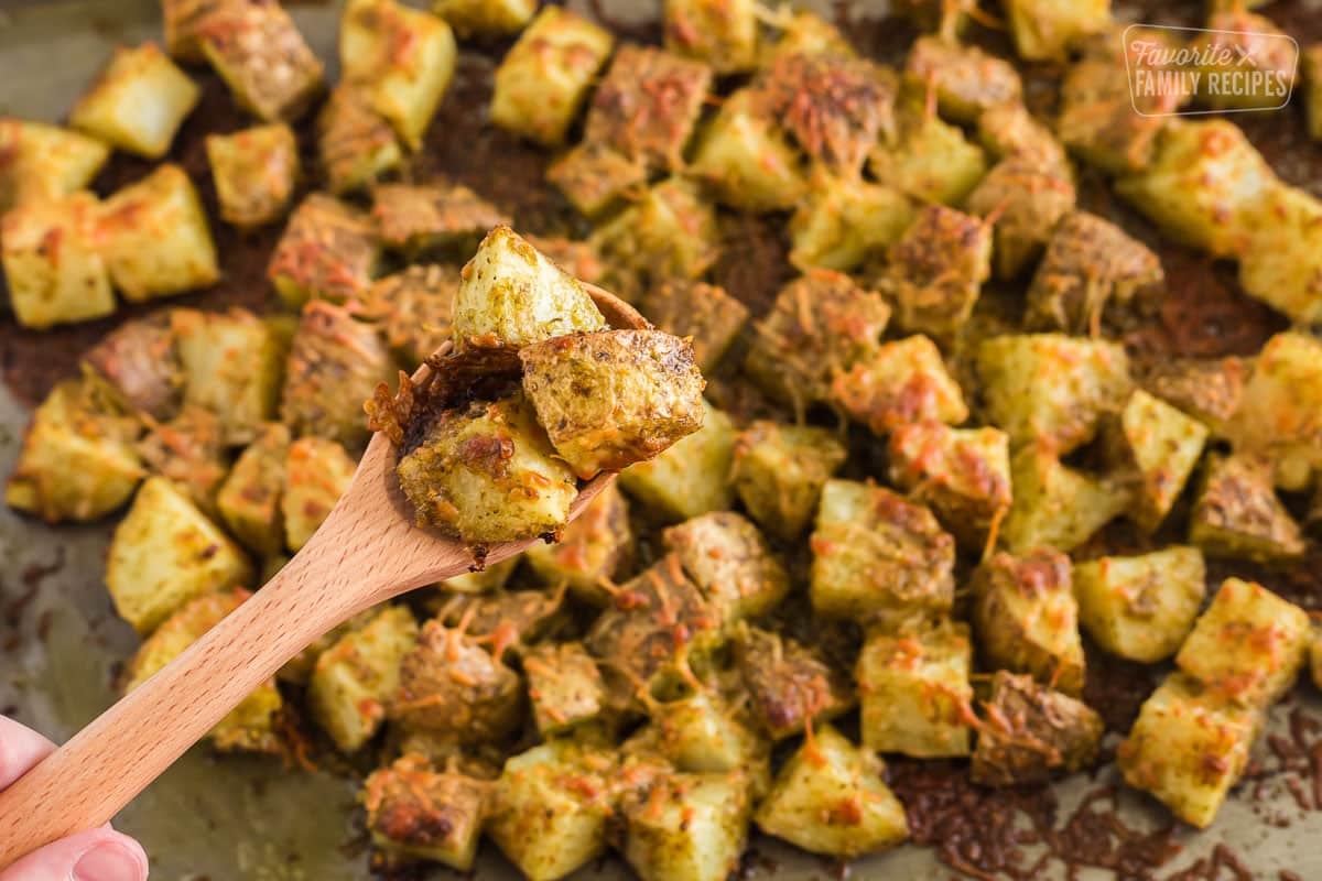 Pesto potatoes on a tray with spoon scooped full of them