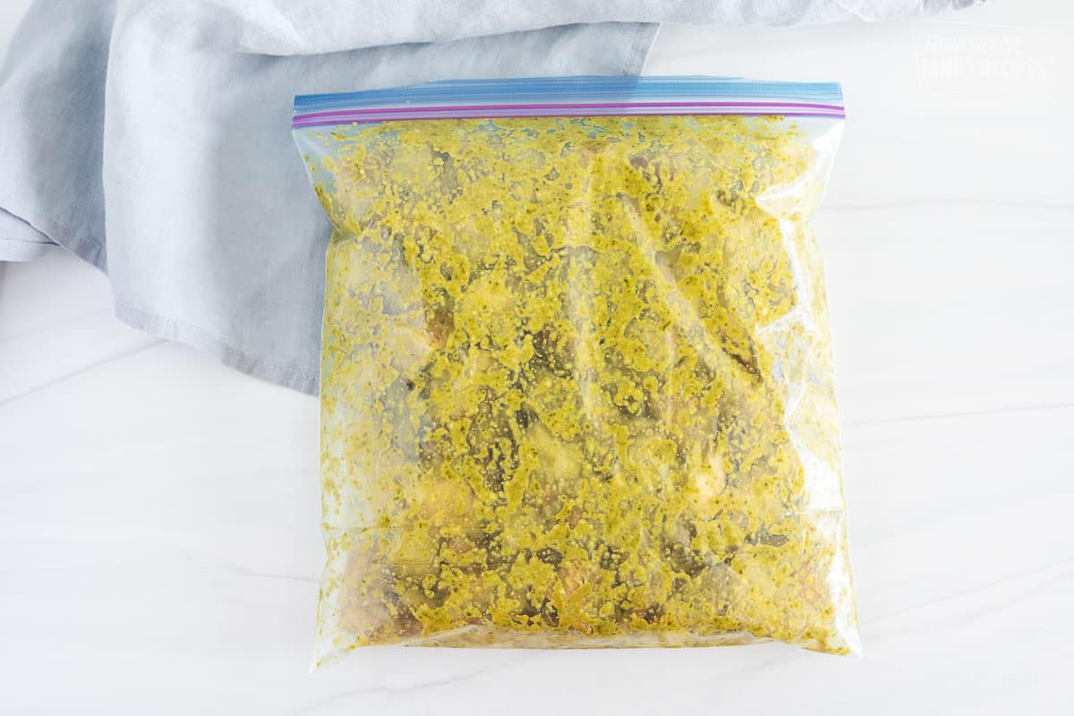 Potatoes and pesto tossed together in a plastic bag