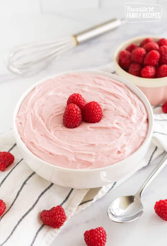 Raspberry Frosting in a bowl topped with raspberries