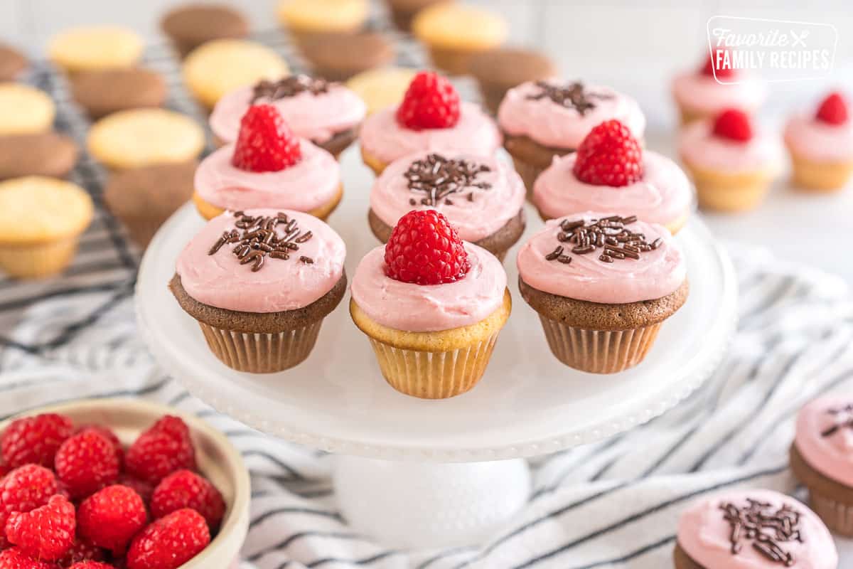 Mini cupcakes with raspberry frosting on a cake plate