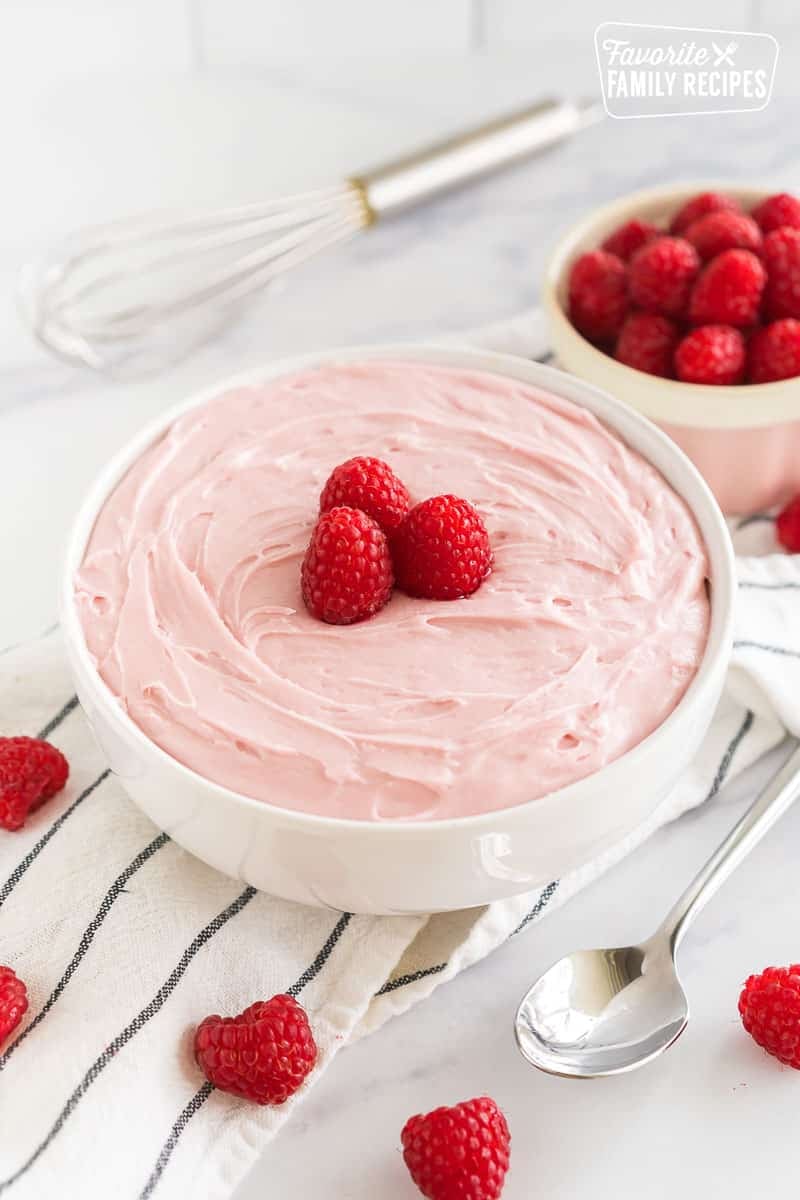 Raspberry Frosting in a bowl topped with raspberries