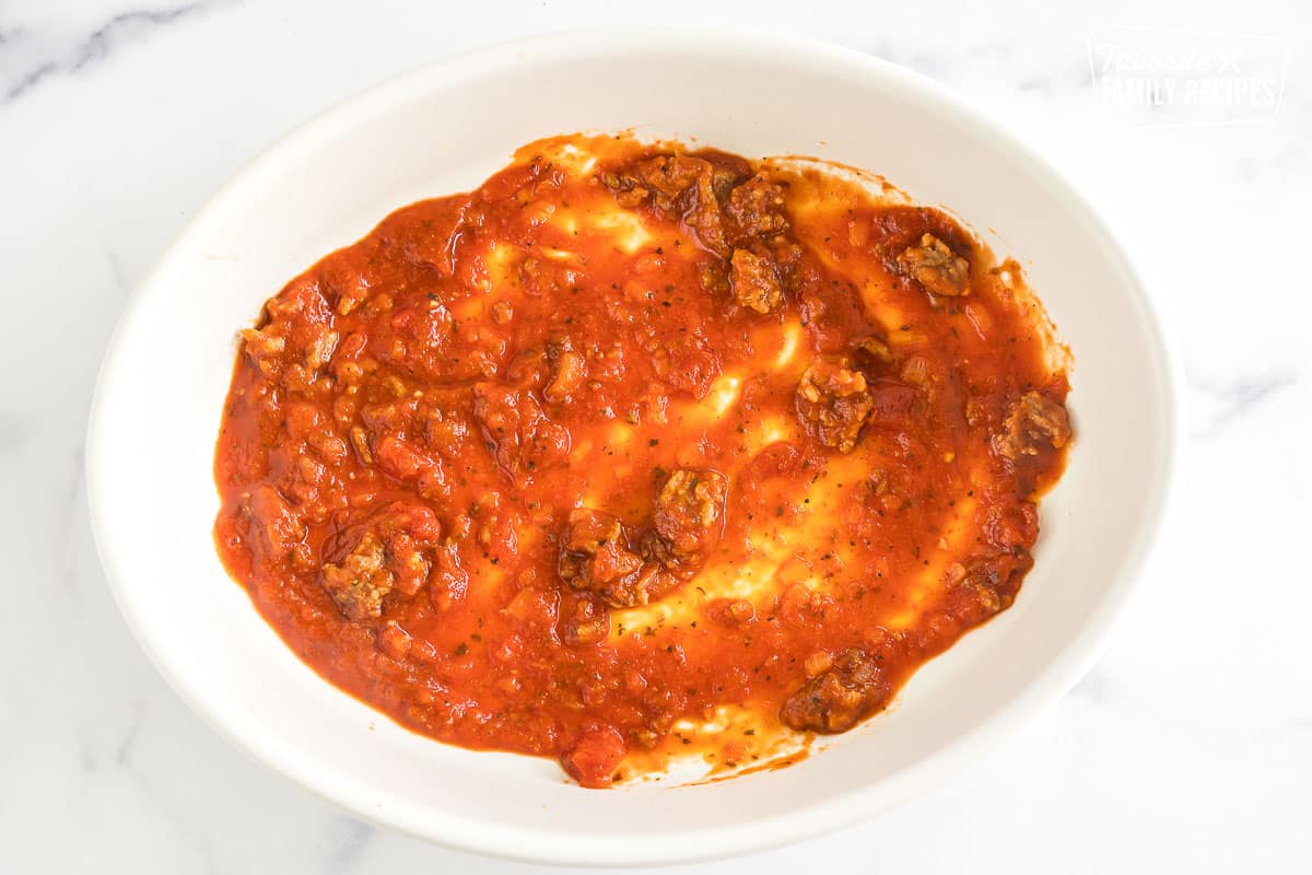 a casserole dish with a thin layer of meat sauce on the bottom