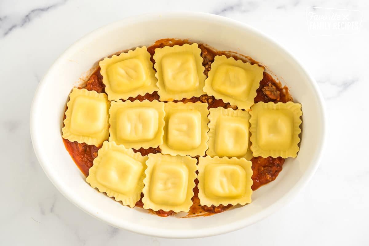 A casserole dish with meat sauce and a layer of ravioli