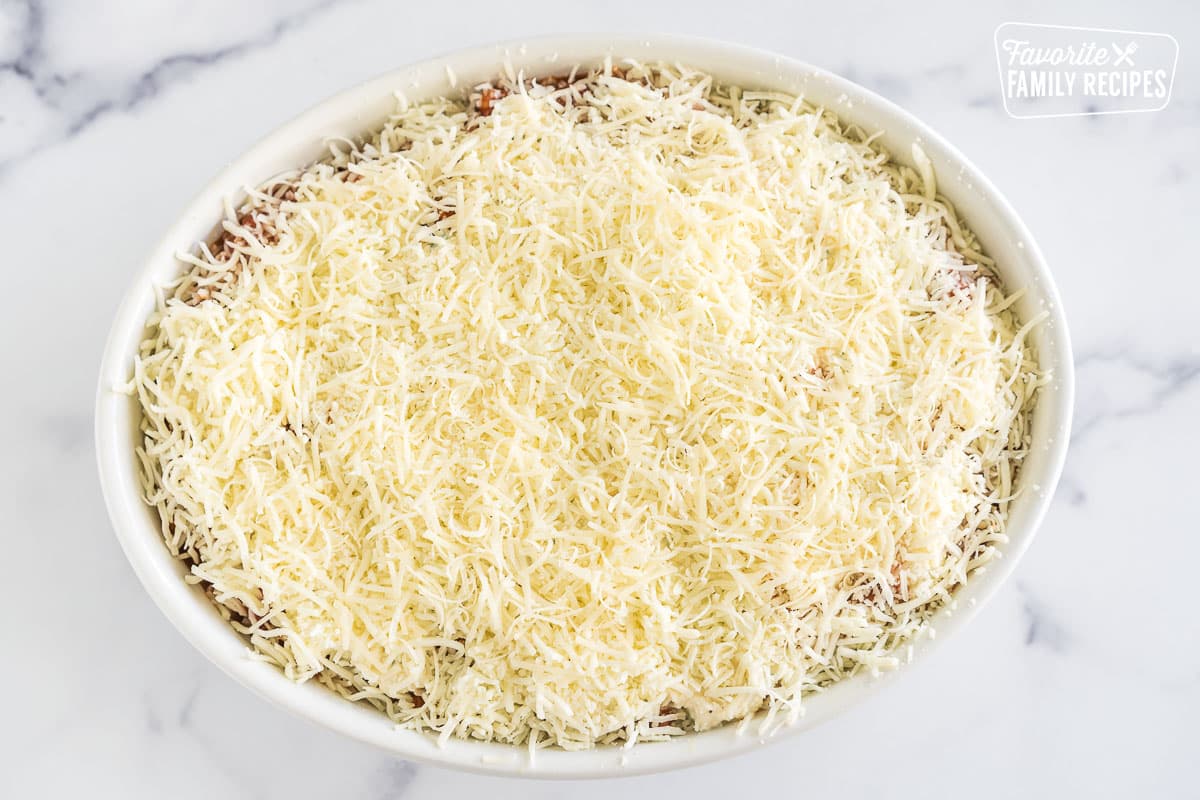 A casserole dish with layers of meat sauce, cheese mixture, and ravioli
