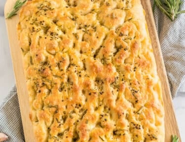 A loaf of Rosemary Garlic Focaccia Bread on a cutting board