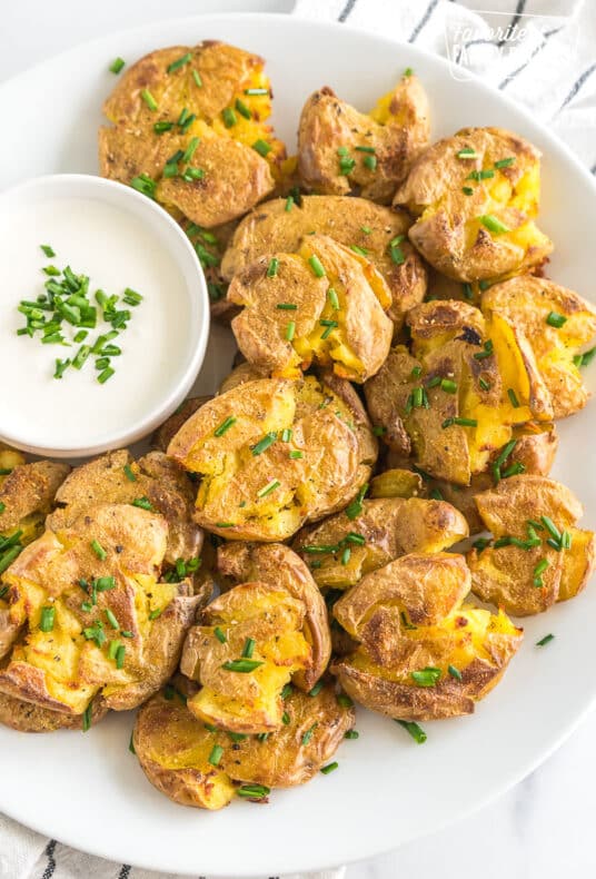 Smashed potatoes on a plate topped with chives