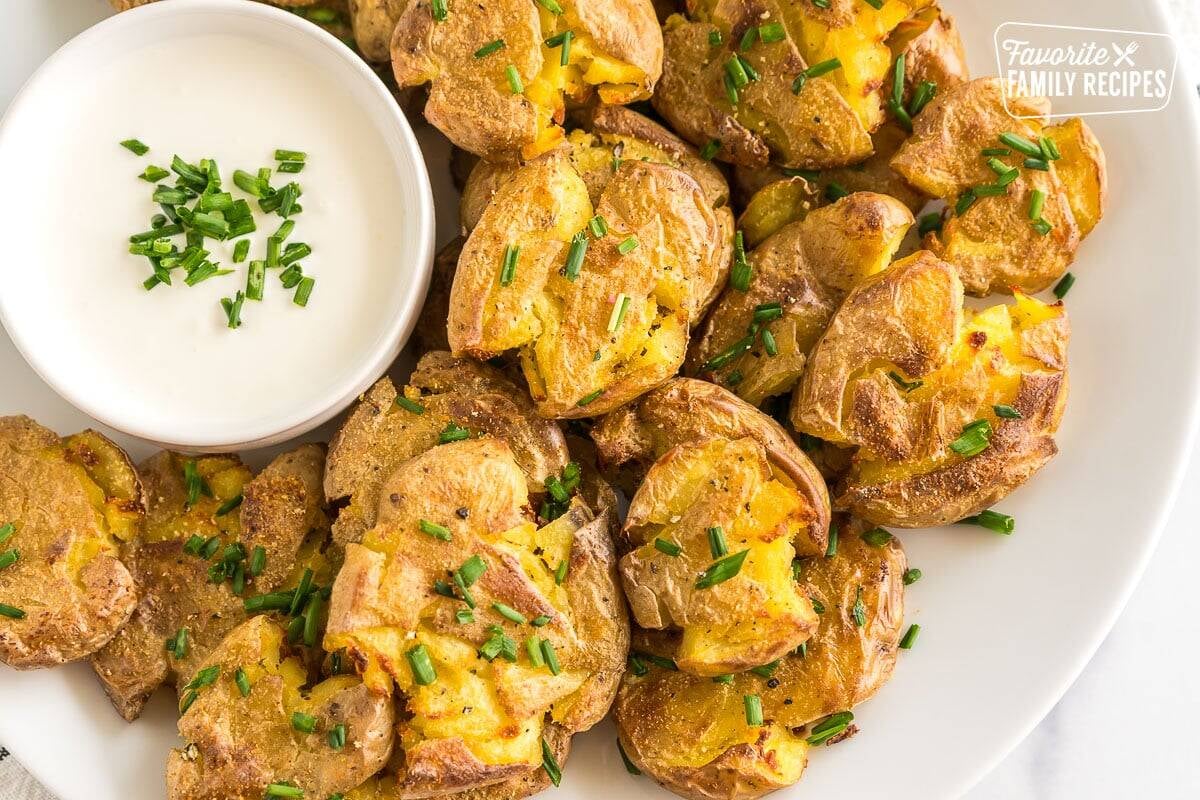 Smashed potatoes on a plate topped with chives