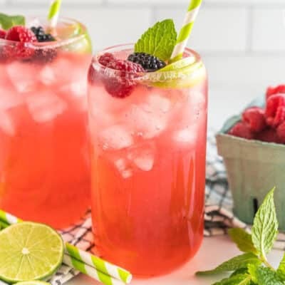 A Sparkling Berry Mojito Mocktail garnished with berries, lime, and mint