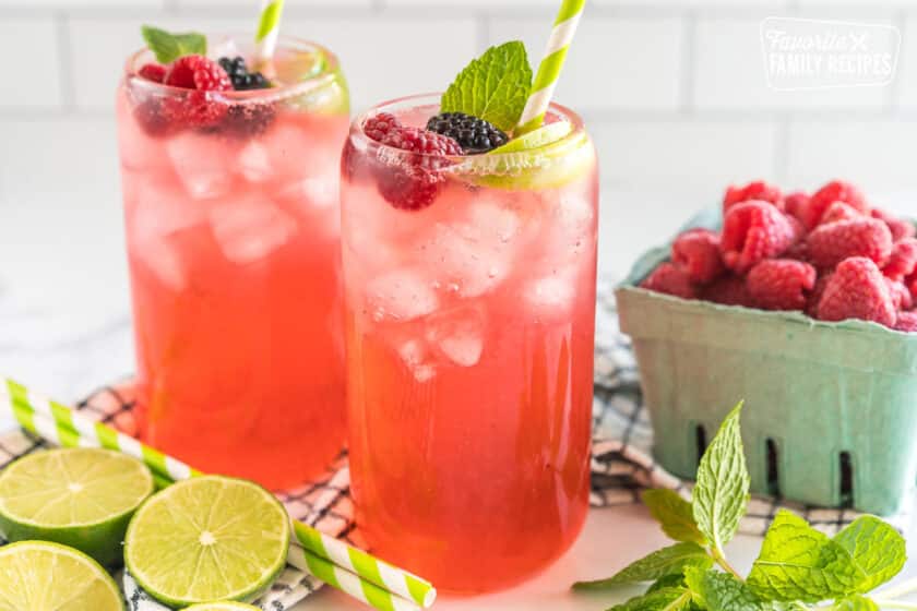 A Sparkling Berry Mojito Mocktail garnished with berries, lime, and mint