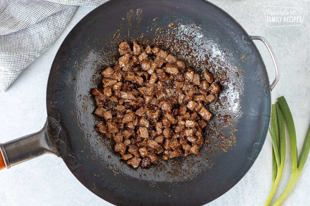 Cooked steak pieces in a wok.