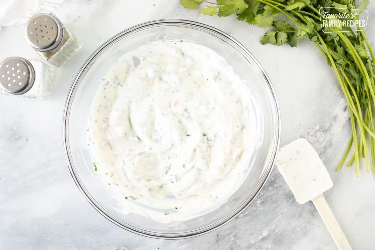 Cucumber yogurt dip in a glass bowl.