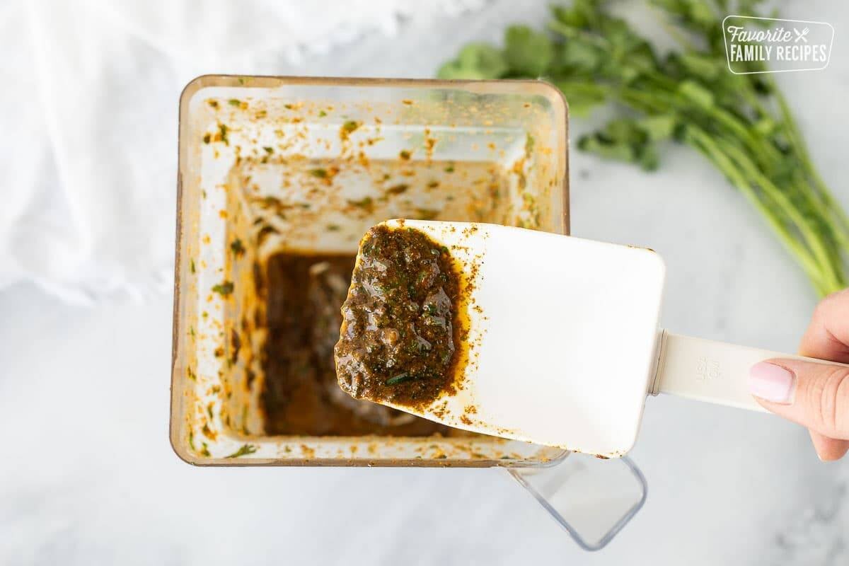 Thai chicken marinade in a blender with a spatula spooned.