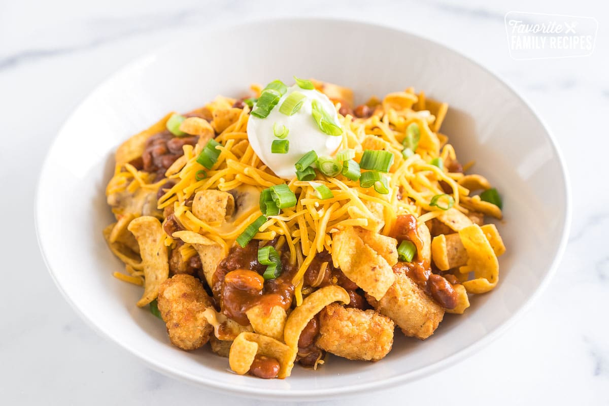 Tater tots topped with chili, queso, cheese, sour cream, fritos, and green onions