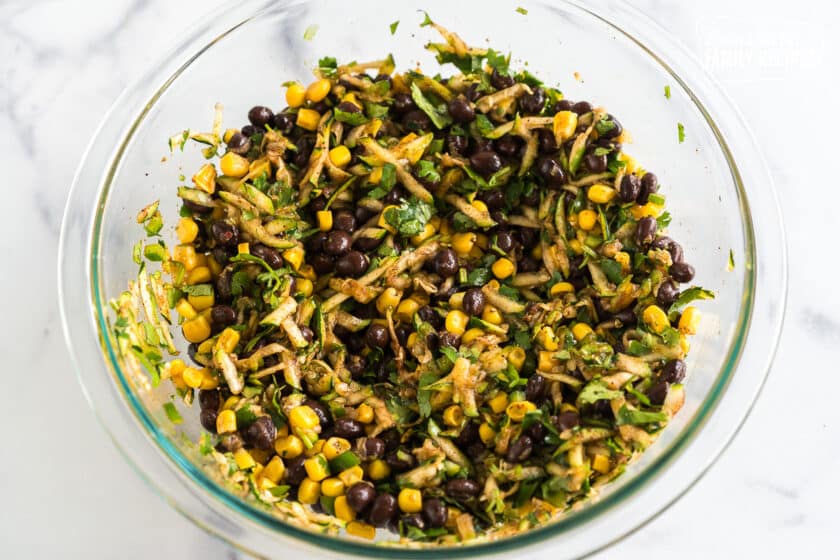 Black beans, corn, zucchini, and spices in a bowl