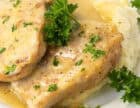 Fork-tender pork chops with creamy homemade gravy on a plate, ready to serve.