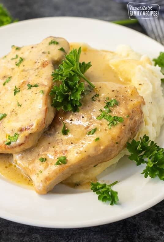 Fork-tender pork chops with creamy homemade gravy on a plate, ready to serve.