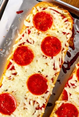 Two baked French Bread Pizzas on a sheet pan.