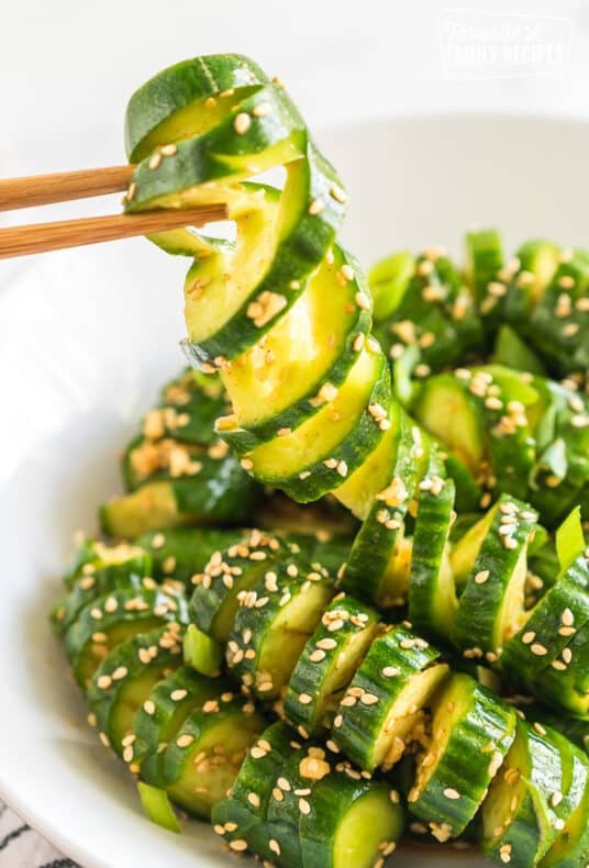 Chopsticks pulling up a bite of spicy cucumber salad