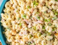 Large bowl of Macaroni Salad. Wooden spoon the side.