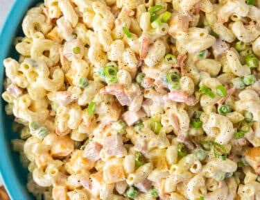 Large bowl of Macaroni Salad. Wooden spoon the side.