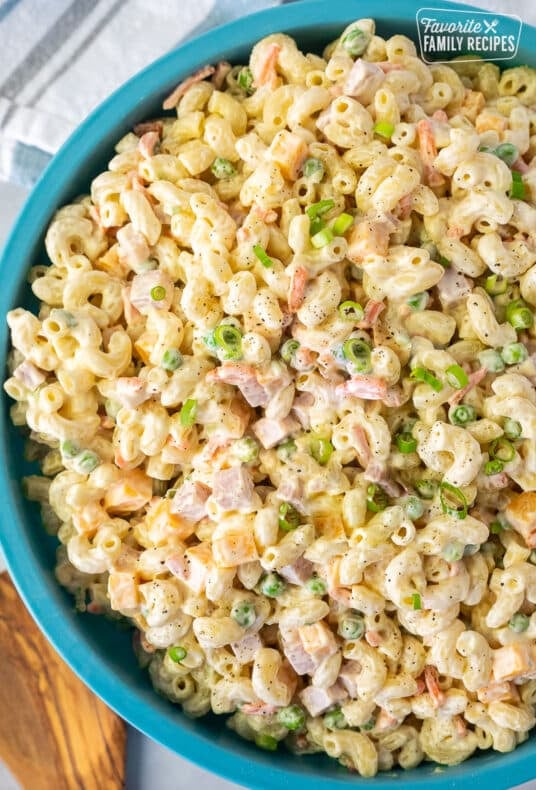 Large bowl of Macaroni Salad. Wooden spoon the side.