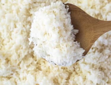 Wooden spoon of cooked rice.