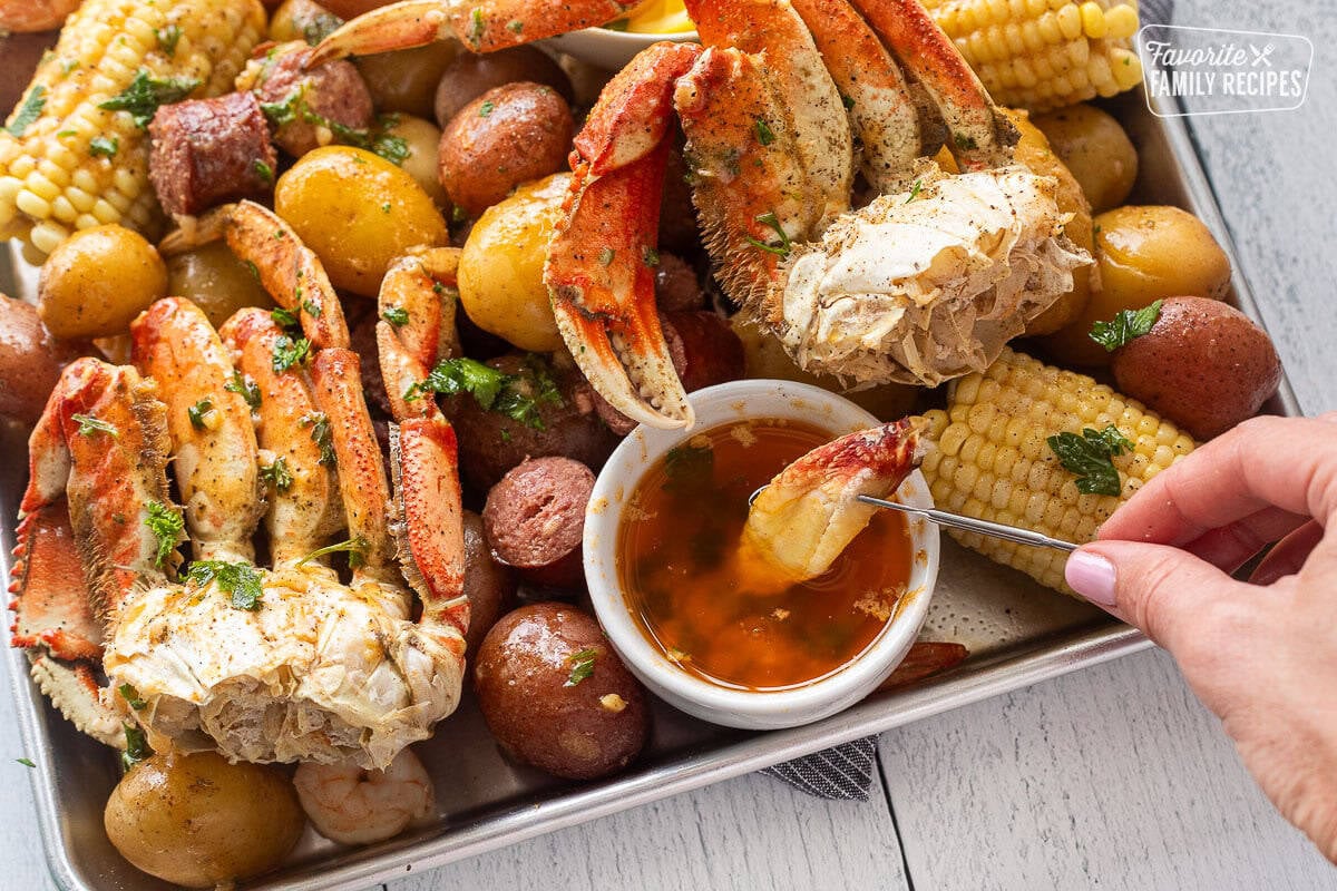 Dipping a piece of crab into a butter garlic.