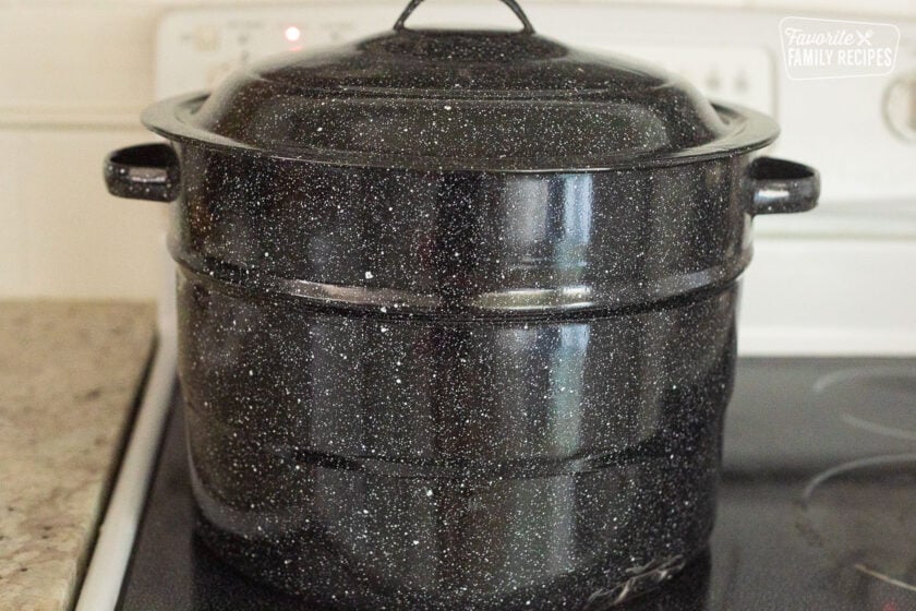 Lid on top of canning pot on a stovetop.